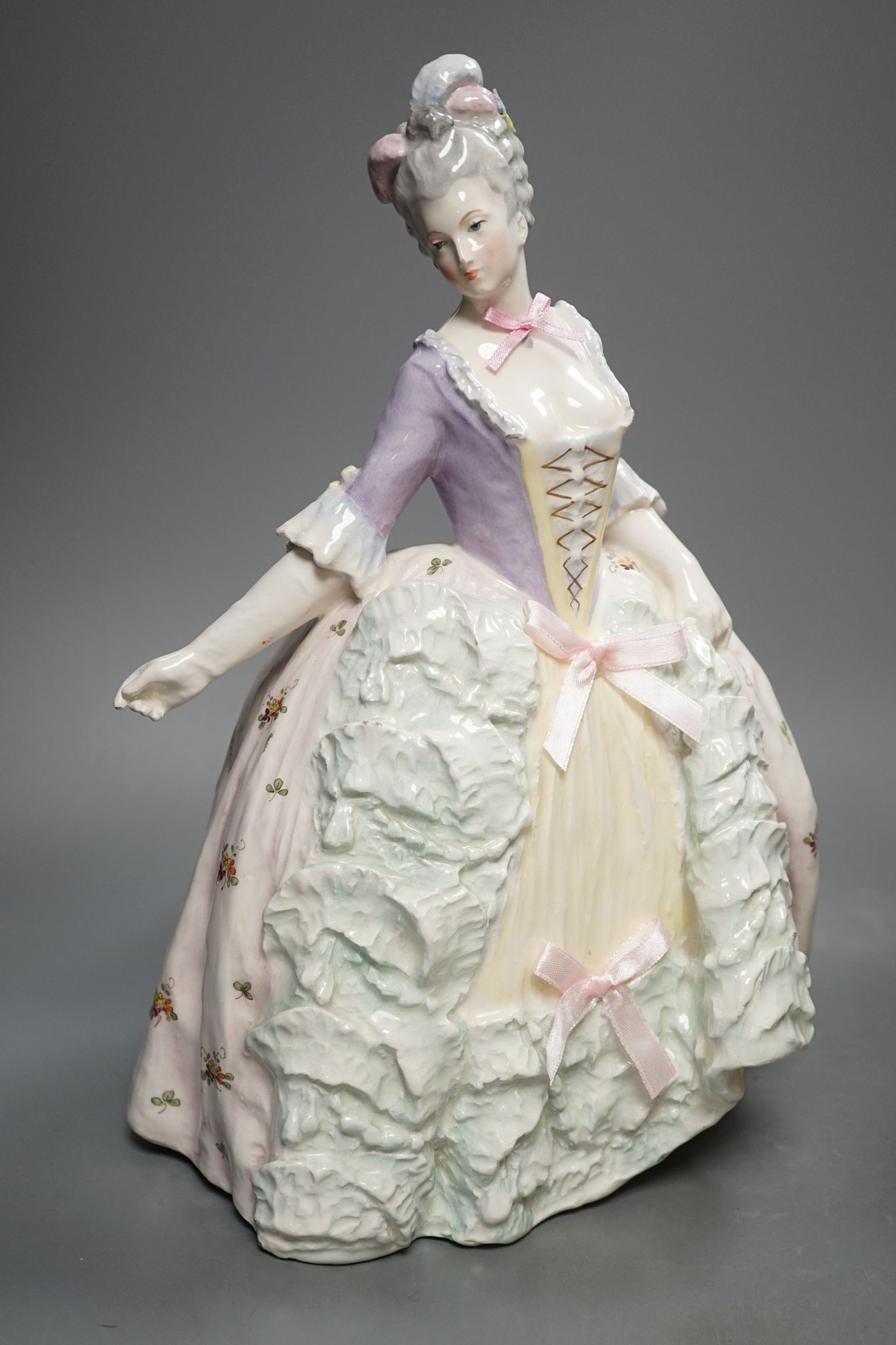 An Italian porcelain group of a dancing couple, 31cm, and an Italian maiolica figure of a lady